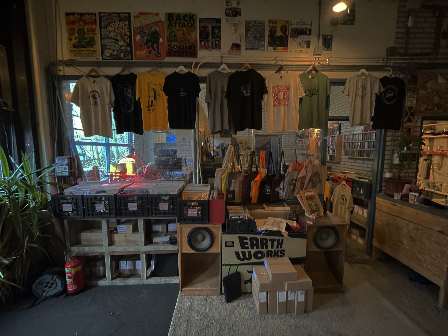 Earth Works merch — tees and totes hanging in the shop